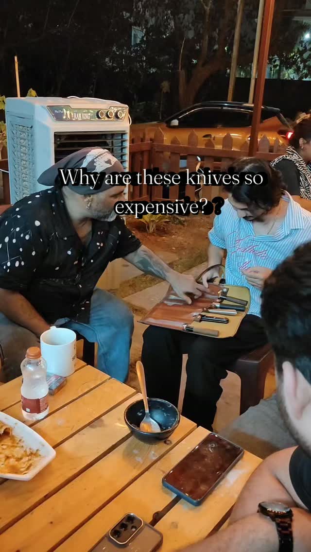 Chef Karl showing his knife roll to guests at QnQ Cafe's open-air tables in Sainikpuri at night